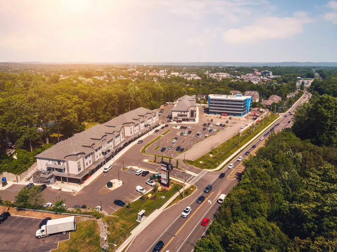 Aerial photo of the building beside Route 59 with its landscaped parking and neighboring residences