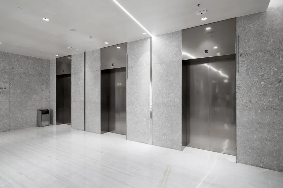 Elevator lobby with stone walls and brushed steel elevator doors